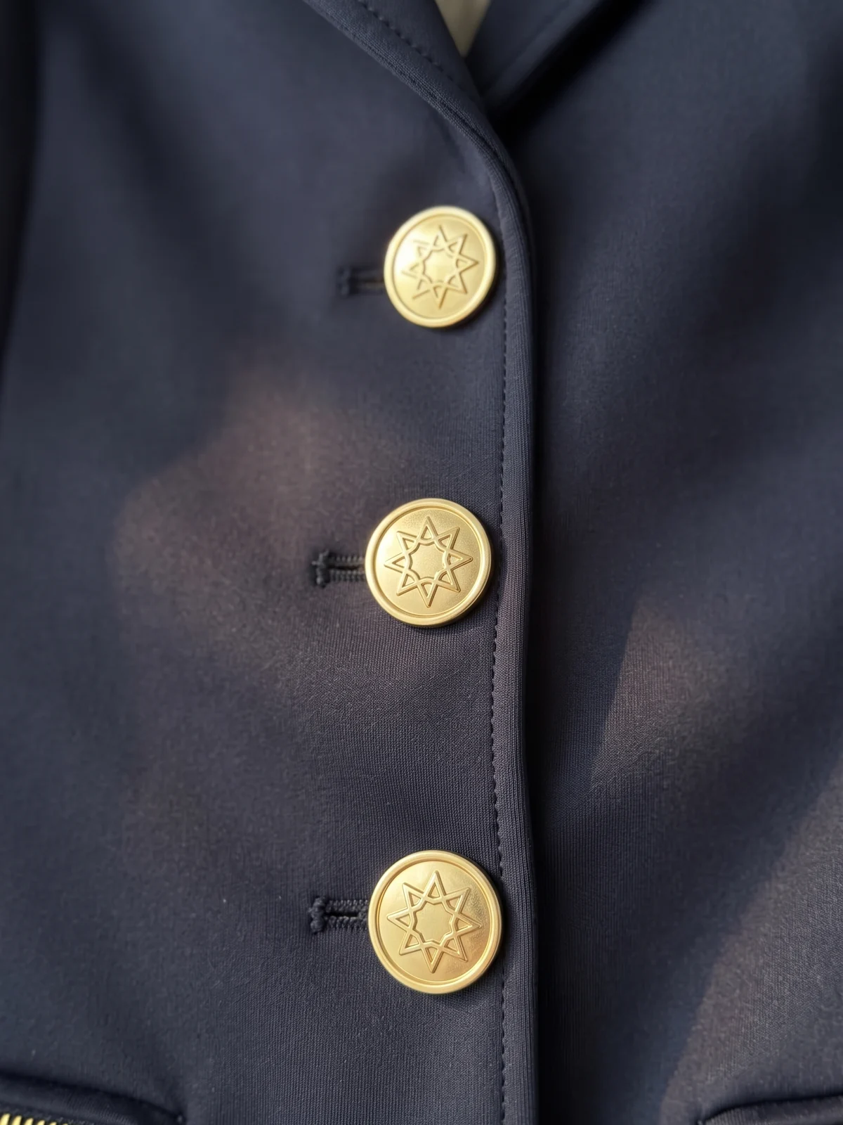 Metallknöpfe mit geprägtem Logo an einem Turniersakko – KI-generierte Illustration