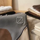 Stickerei mit einem abstrakten Logo am Oberschenkel einer Reithose – KI-generierte Illustration