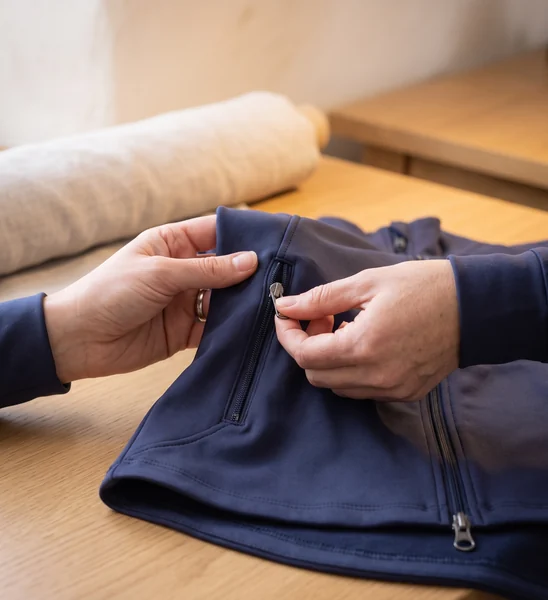 Prüferin zieht den Taschenreißverschluss einer Trainingsjacke auf und zu – KI-generierte Illustration