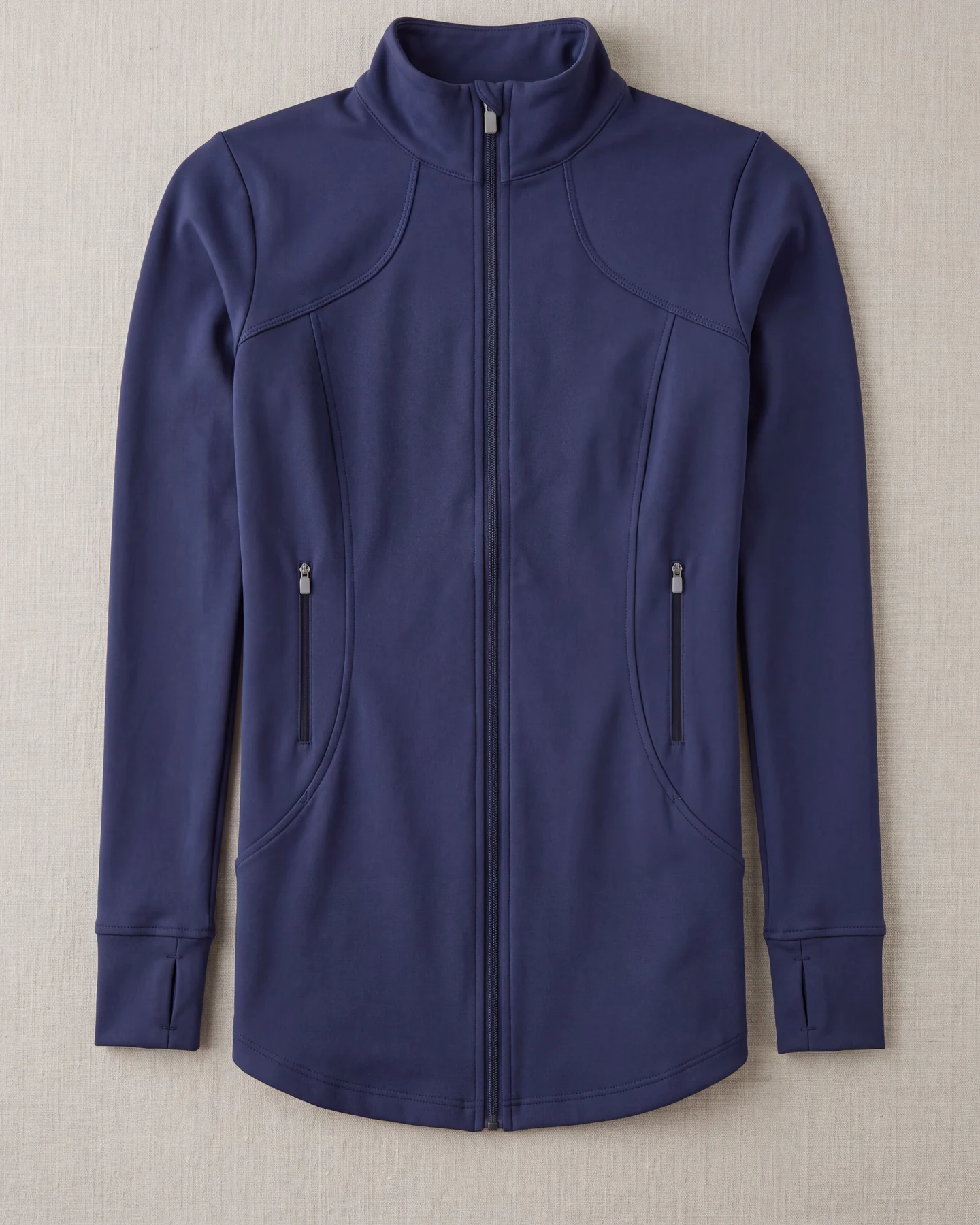 Trainingsjacke in Navy flach ausgelegt von oben, mit Frontreißverschluss und zwei Taschenreißverschlüssen – KI-generierte Illustration