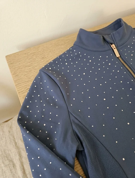 Strass auf der Schulter eines Navy Reitshirts, nach außen lichter werdend – KI-generierte Illustration