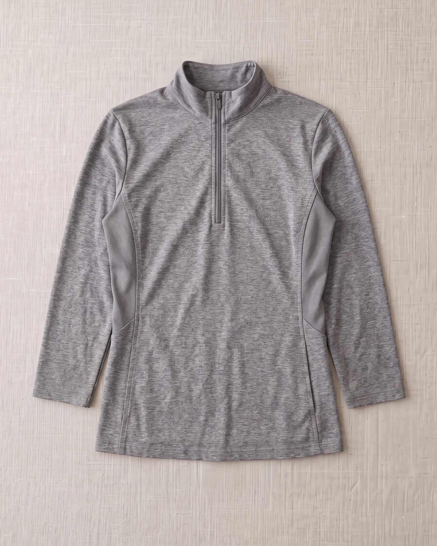 Referenzteil: getragenes Langarm-Reitshirt in Grau meliert flach liegend, von oben – KI-generierte Illustration