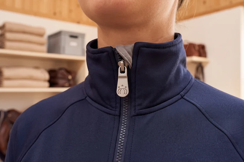 Zipper-Puller aus Metall mit Vereinswappen an einer Trainingsjacke – KI-generierte Illustration