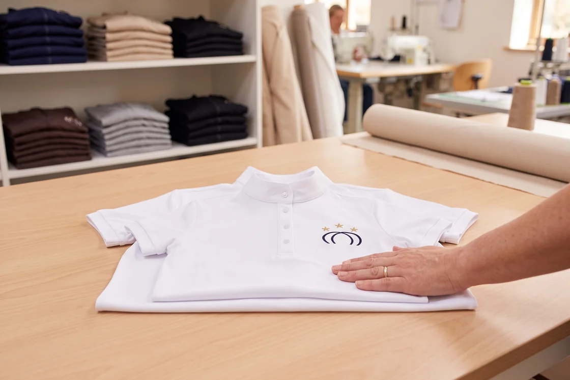 Prüfung vor dem Versand: Turniershirt in Kindergröße und Erwachsenengröße übereinander, Wappen an derselben Stelle – KI-generierte Illustration