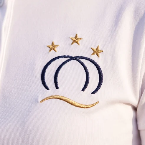 Gesticktes Vereinswappen auf einem Turniershirt, darunter eine gestickte Zierlinie an der Stelle für den Namen – KI-generierte Illustration