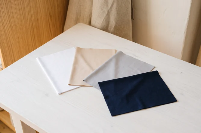 Aufgefächerte Stretchstoff-Muster in Weiß, Beige, Grau und Navy – KI-generierte Illustration