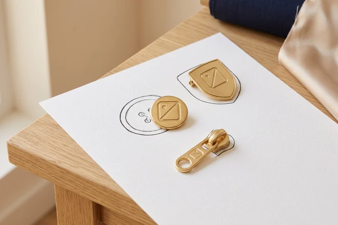 Metallknopf, Emblem und Zipper-Puller als Vorabmuster auf einer leeren Zeichnung – KI-generierte Illustration