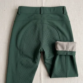 Vollgrip mit Punktmuster an einer dunkelgrünen Winterreithose – KI-generierte Illustration
