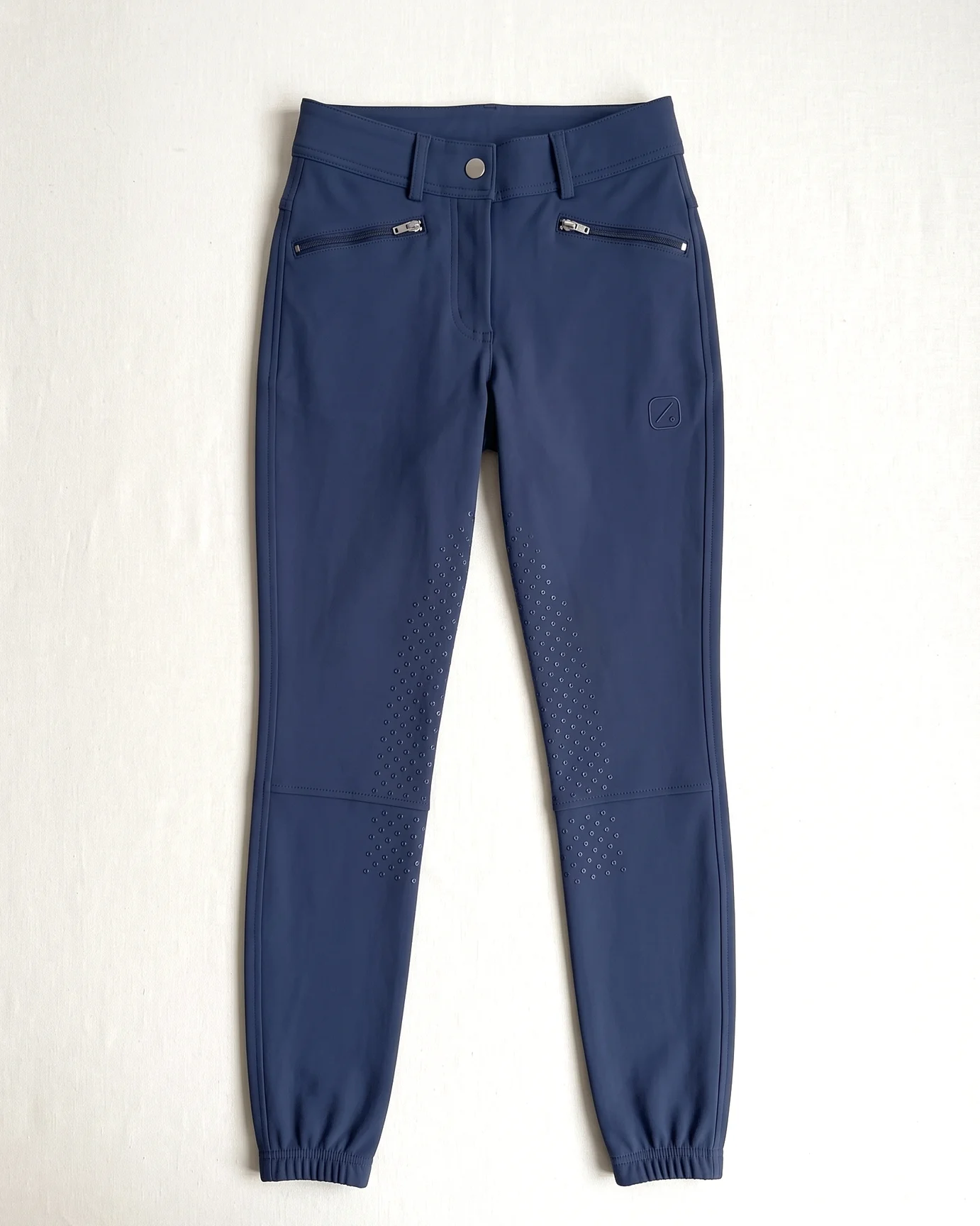Navy Winterreithose flach liegend von vorn: Knopfbund, Taschen, Stickerei am Oberschenkel, Kniegrip, elastischer Saum – KI-generierte Illustration