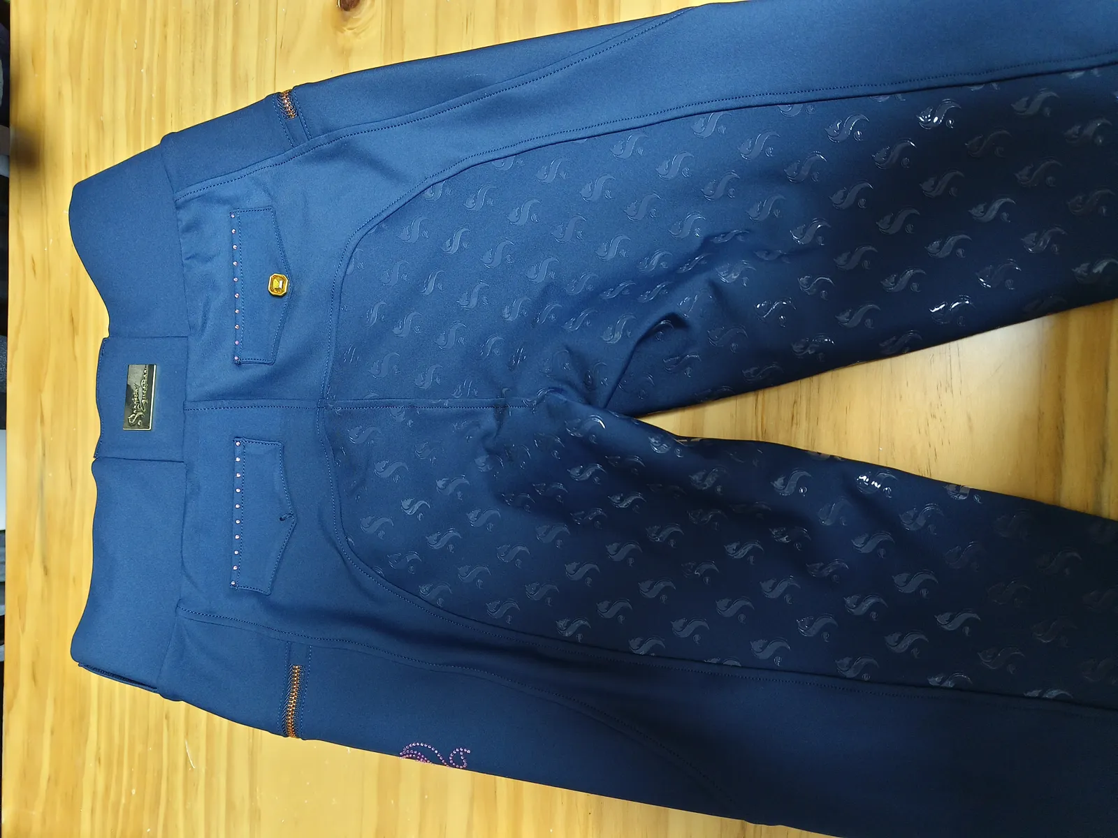 Bund einer blauen Reithose mit Logo-Knopf und Silikon-Grip, Nahaufnahme