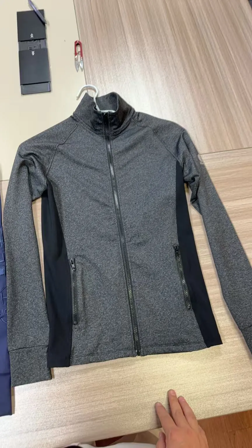 Graue Trainingsjacke auf dem Bügel, Ausschnitt Stehkragen und Reißverschluss